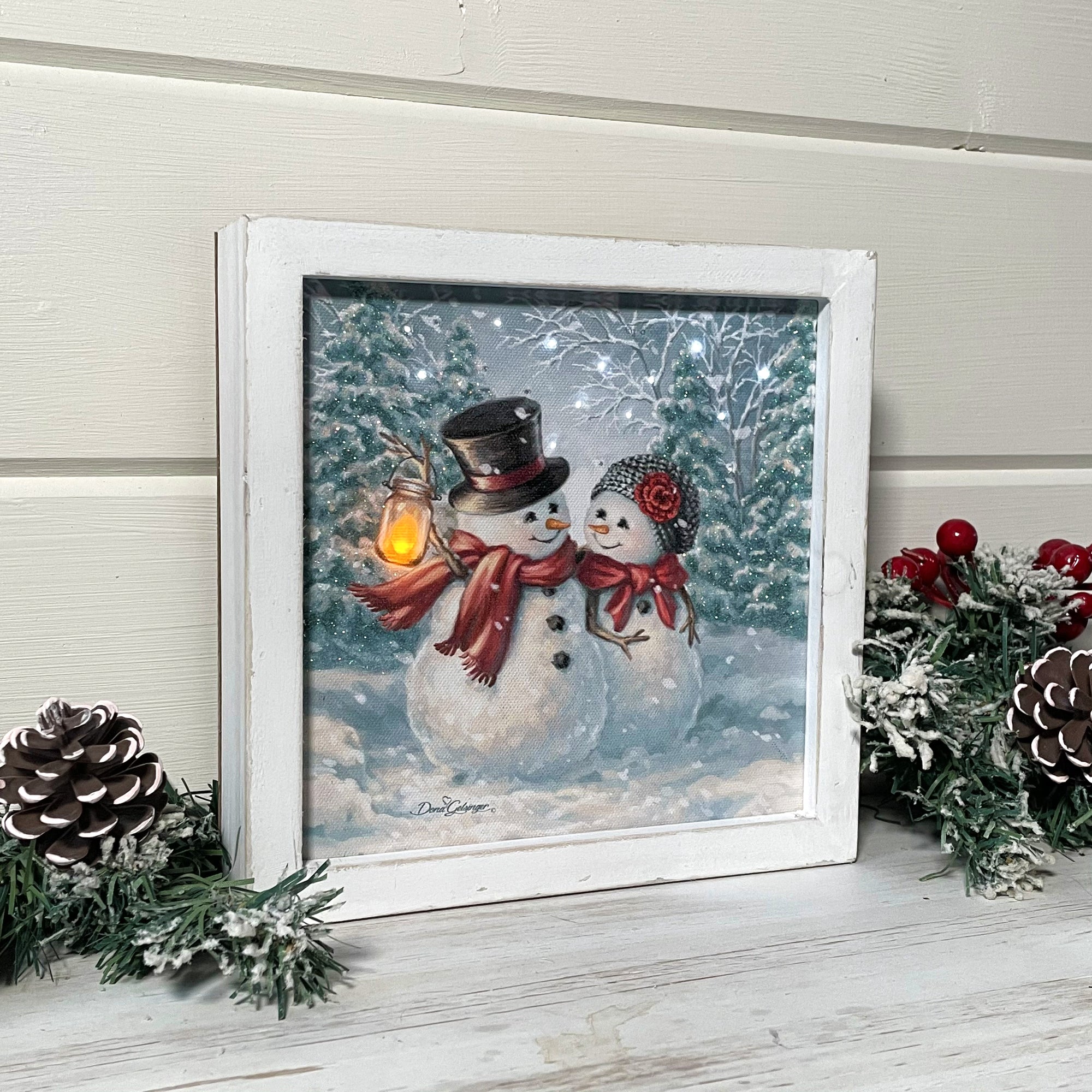  Featuring two adorable snowmen, snuggled up close and gazing lovingly into each other's eyes, this charming piece is sure to warm your heart.  With their cozy scarves, top hat and beanie, these snowmen are ready for whatever winter throws their way. And the snow-covered woods in the background add a touch of rustic charm to this already enchanting scene.