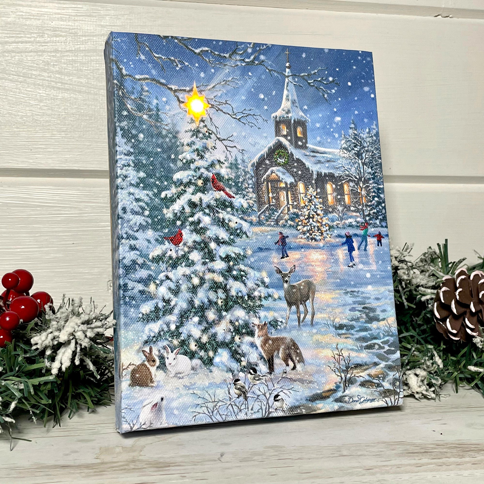 This beautifully crafted canvas features a stunning snow covered pine tree, adorned with sparkling lights that shine and twinkle in the night. A bright star sits at the very top of the tree, adding an extra touch of charm and wonder to this delightful scene.  As you take a closer look, you'll notice a cast of woodland creatures gathered around the tree, including bunnies, fox, deer, and cardinals.