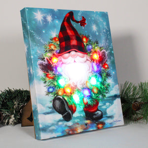 This jolly gnome, adorned in a plaid beanie and a long, full white beard, is sure to capture your heart with its delightful presence.  Wrapped around its neck is a colorfully lit wreath, adding a touch of festive charm to any room.