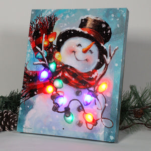 Dressed in a cozy plaid scarf and top hat, this cheerful snowman is ready to bring warmth and joy to your home. With his hands raised in delight, he's the perfect embodiment of the holiday spirit.  But that's not all! The Musical Snowman is adorned with a string of multicolor lights.