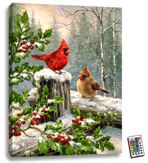  two charming cardinals perched on a wooden fence.  Surrounded by a halo of holly, these majestic birds are brought to life with the help of fully illuminated LED lights that add a touch of magic to any room