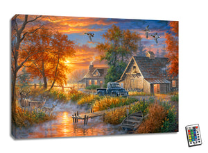 This stunning 18x24 piece captures the essence of an idyllic country farm, complete with a family of deer gracefully grazing on the banks of a tranquil creek bed.  As you gaze at this exquisite scene, you'll notice the soft glow of the LED lights highlighting every detail, from the majestic ducks flying across the sky to the charming old blue truck parked by the rustic barn and farmhouse.