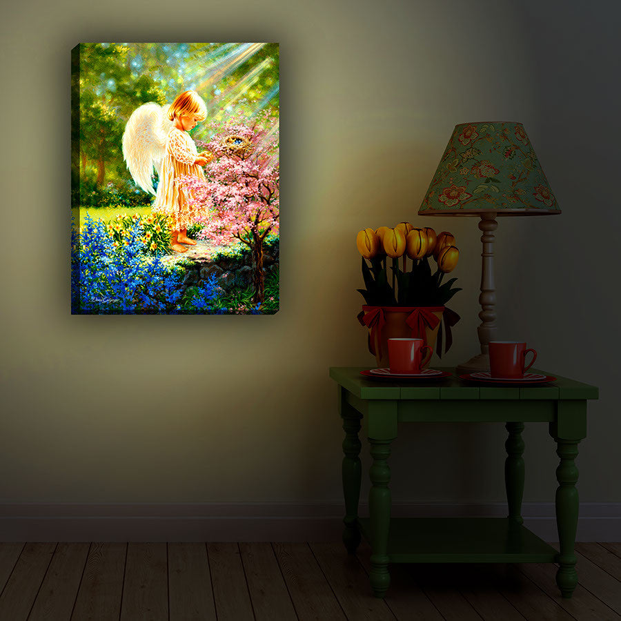 An Angel's Tenderness 18x24 Fully Illuminated LED Art. An angel in a beautiful garden staged in a dark room.