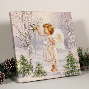 This enchanting print features a young angel standing in a snow-covered forest, reaching up towards a beautiful bird perched atop a tree branch.