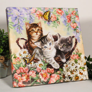 Featuring three adorable kittens nestled in a woven basket surrounded by a plethora of colorful flowers and fluttering butterflies, this print is sure to capture your heart.  But the magic doesn't stop there - this print is also adorned with dazzling crystals that add a touch of sparkle and glam to any room.