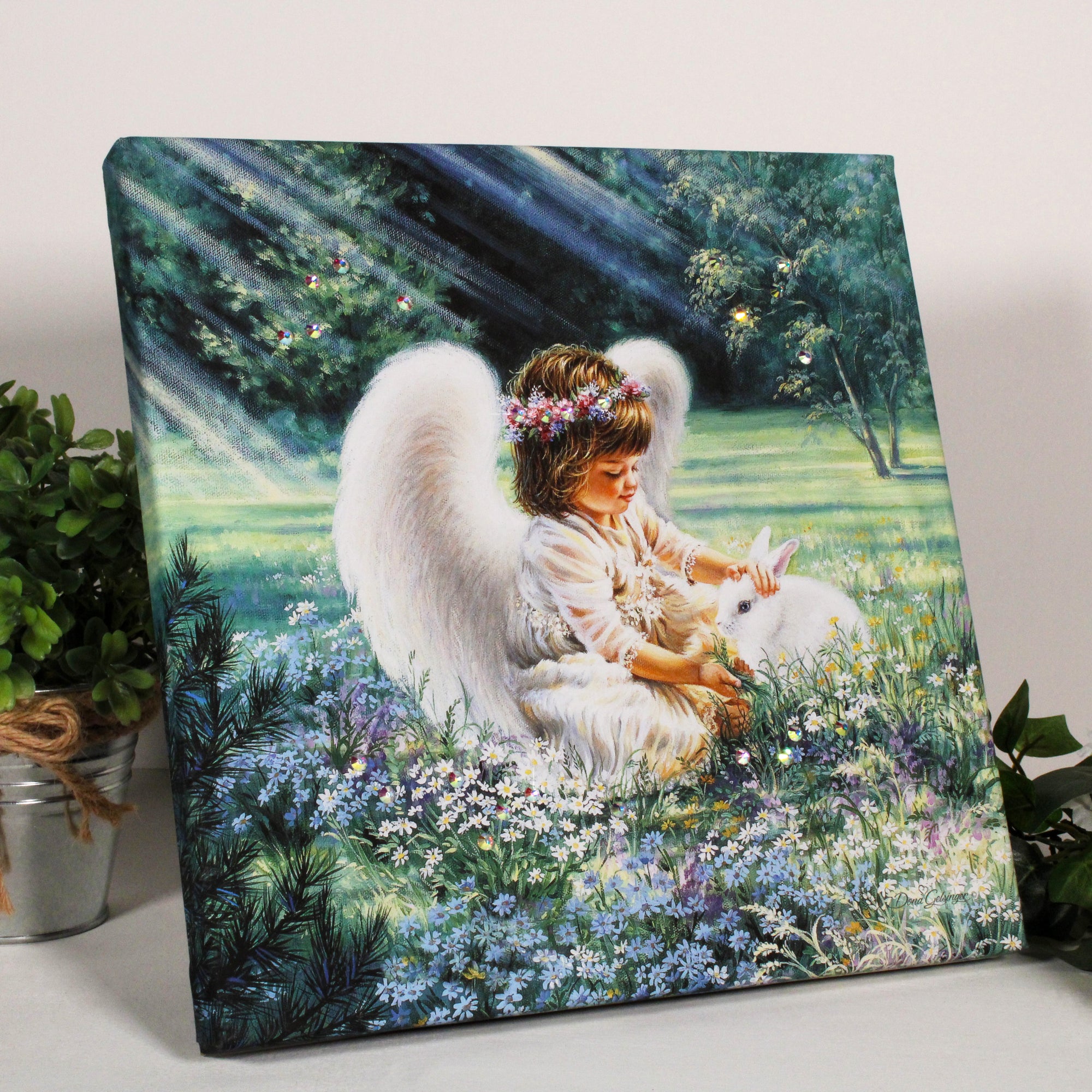 This stunning piece of art captures the essence of pure, unadulterated love with a young angel tenderly petting a bunny nestled in a bed of colorful flowers.