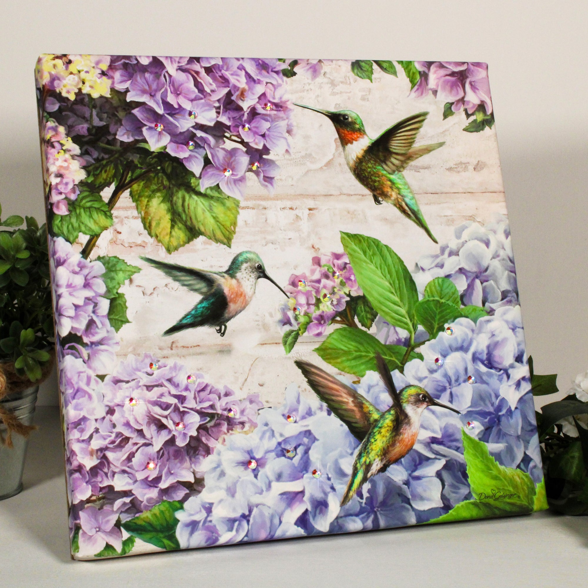 This print captures the graceful elegance of hummingbirds as they delicately sip nectar from vibrant purple and blue hydrangeas, creating a breathtaking scene of natural wonder.