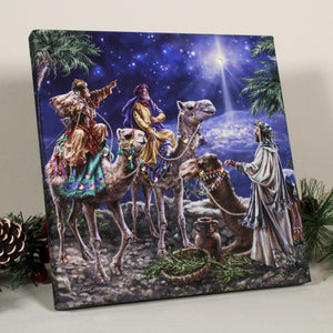 This stunning print captures the enchanting moment when the three wise men and their camels follow the bright star shining down on Bethlehem, leading them to the birthplace of Jesus.