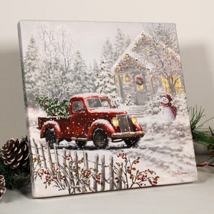 a vintage red truck parked in front of a cozy cottage.  In the bed of the truck, you'll find a freshly cut tree, ready to be brought inside and decorated with your loved one. And with the truck's LED headlights shining bright