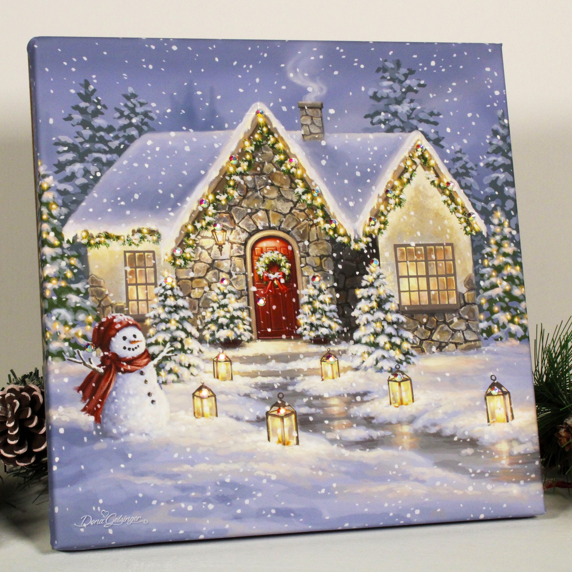  With a snowman standing proudly in the front yard and lanterns on either side of the path leading to the house, this print captures the magic and romance of the holiday season.  The snowflakes falling softly from the sky are captured in stunning detail, and the gentle glow of the Christmas lights add a touch of whimsy and enchantment.