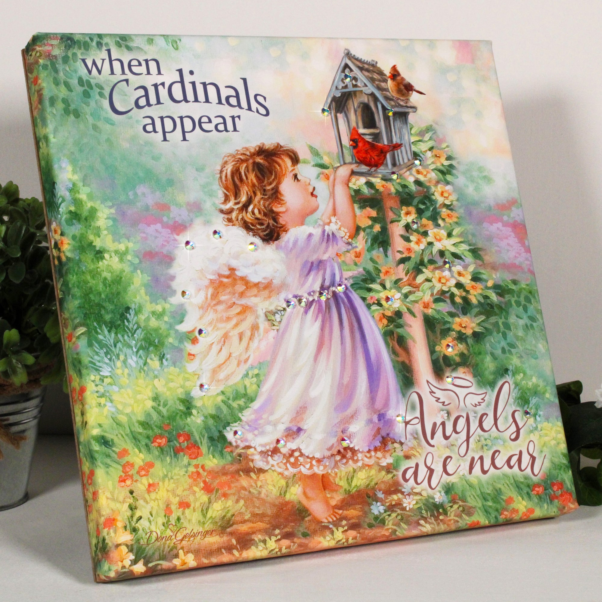  Angels Appear Pizazz Print, featuring a charming young angel gazing at two beautiful cardinals perched atop a cozy birdhouse.