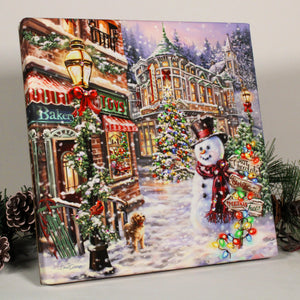 This print captures the magic of the holiday season in a charming small town downtown setting.  With its whimsical depiction of Christmas trees, a cheerful snowman, and a playful puppy, this print is the perfect addition to any festive decor. The sparkling crystals add an extra touch of glamour, making it truly shine.