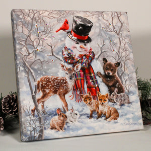 The scene is set with a happy snowman, dressed in his top hat and scarf, surrounded by an array of enchanting forest animals. Adorable bunnies, playful baby foxes, a graceful young deer, a curious young bear, and a majestic cardinal all add to the charm of this picturesque snowy landscape.