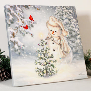 a cheerful snowman gazing upon a beautifully lit pine tree with a star shining bright on top.  With its stunning combination of dazzling crystals and vibrant colors, this print is sure to become the centerpiece of your holiday decor. The snowman, adorned in a cozy white scarf and beanie.