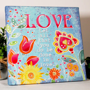 Delight in the whimsical scene of vibrant flowers and lush leaves that evoke feelings of passion and joy.  Crafted with dazzling crystals, this print sparkles with every angle and adds a touch of glamour to any space. The words "love let all that you do be done in love" 