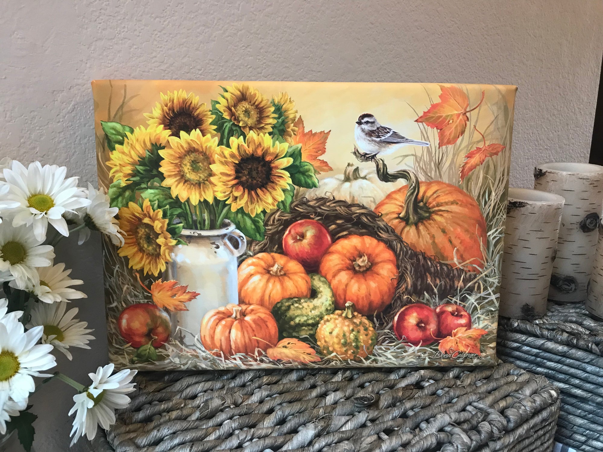 The warm hues of sunflowers sitting in an old fashioned milk jug will fill your heart with joy and nostalgia. Pumpkins, gourds, and apples surround the centerpiece, creating a wholesome and inviting atmosphere.